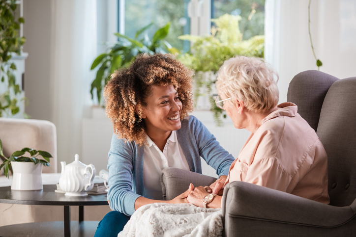 Friendly nurse helping an elderly woman