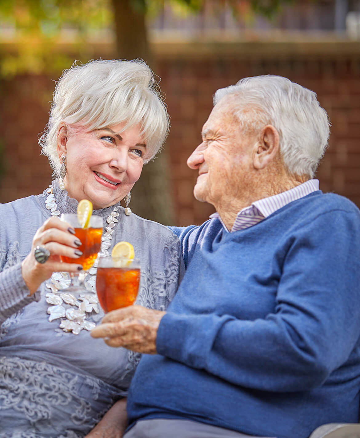 Couple holding ice teas and smiling at each other