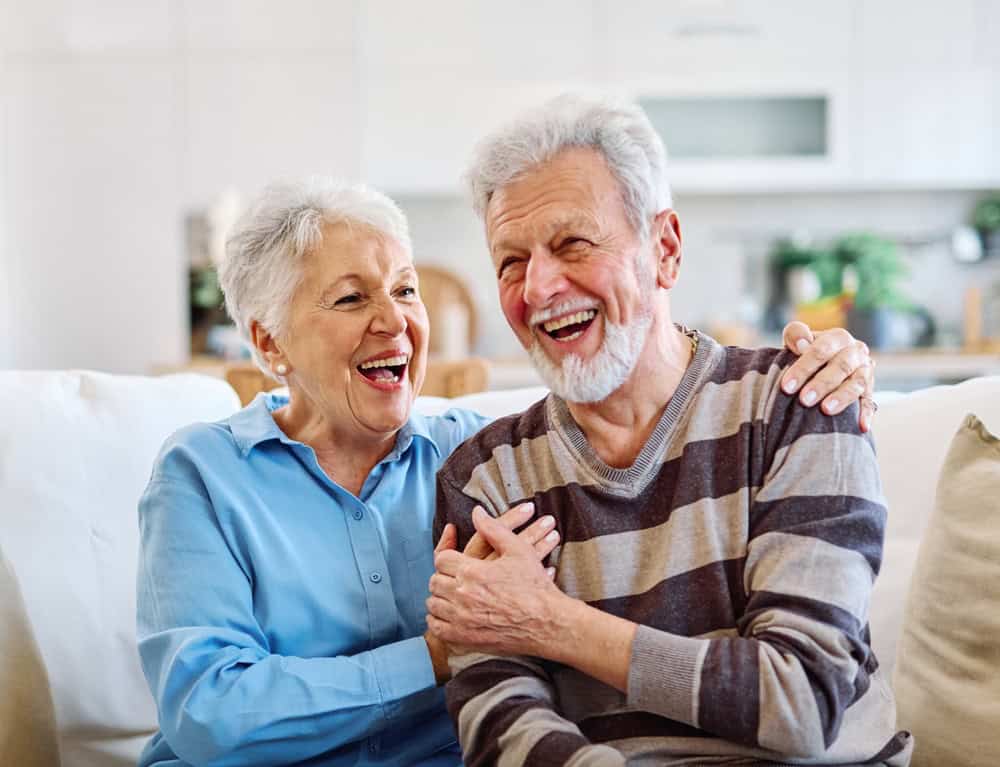 An elderly couple embracing each other