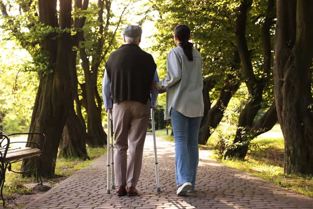 Senior couple walking outdoors, supporting loved one with depression signs.