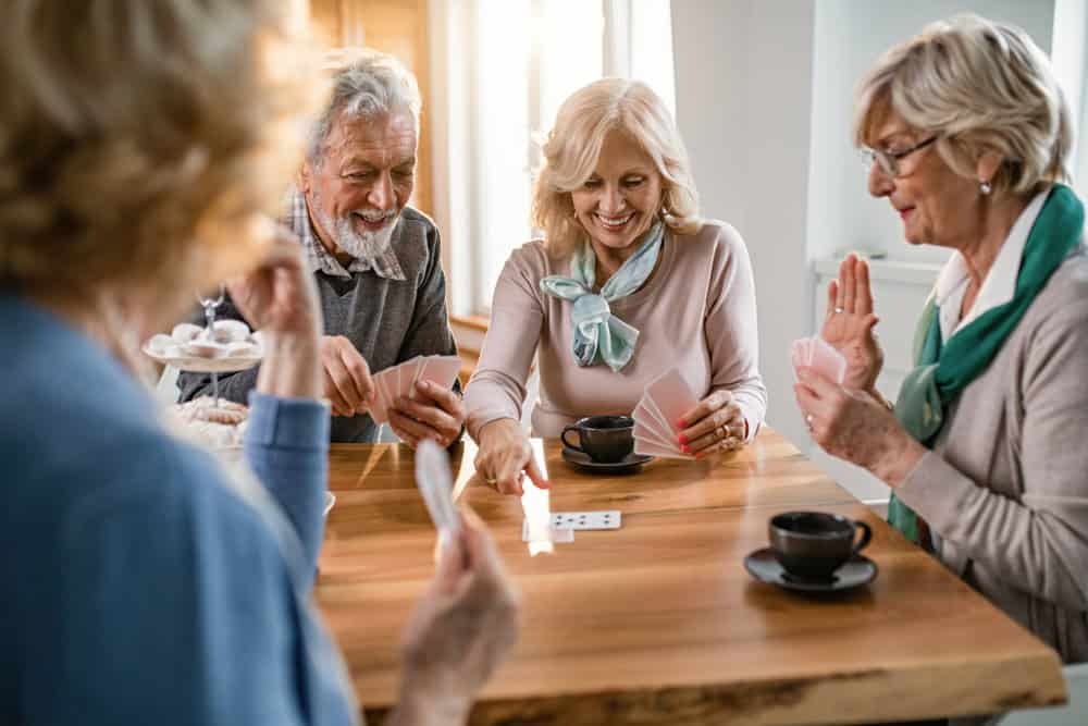 Senior residents enjoying a game of cards together in a welcoming environment.