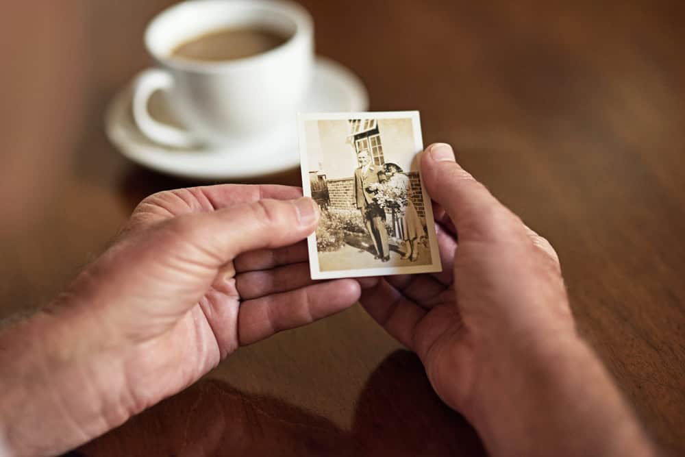Reminiscing with a loved one holding a vintage photograph, highlighting emotional connection and mem.