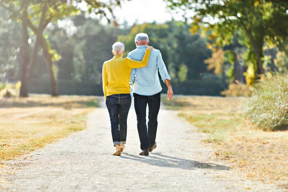 An elderly couple walking out in nature