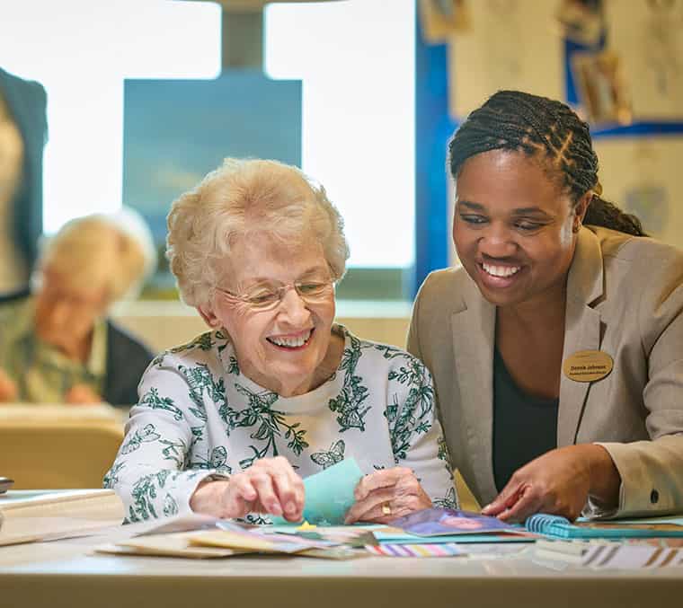 An elderly woman working with a staff member