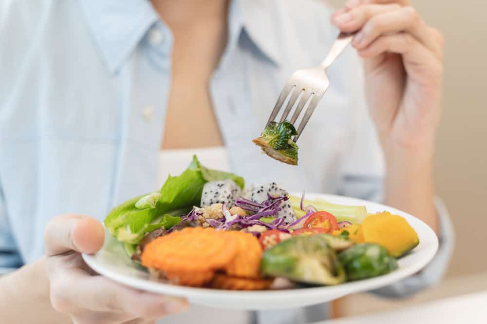 A woman shown eating a healthy meal