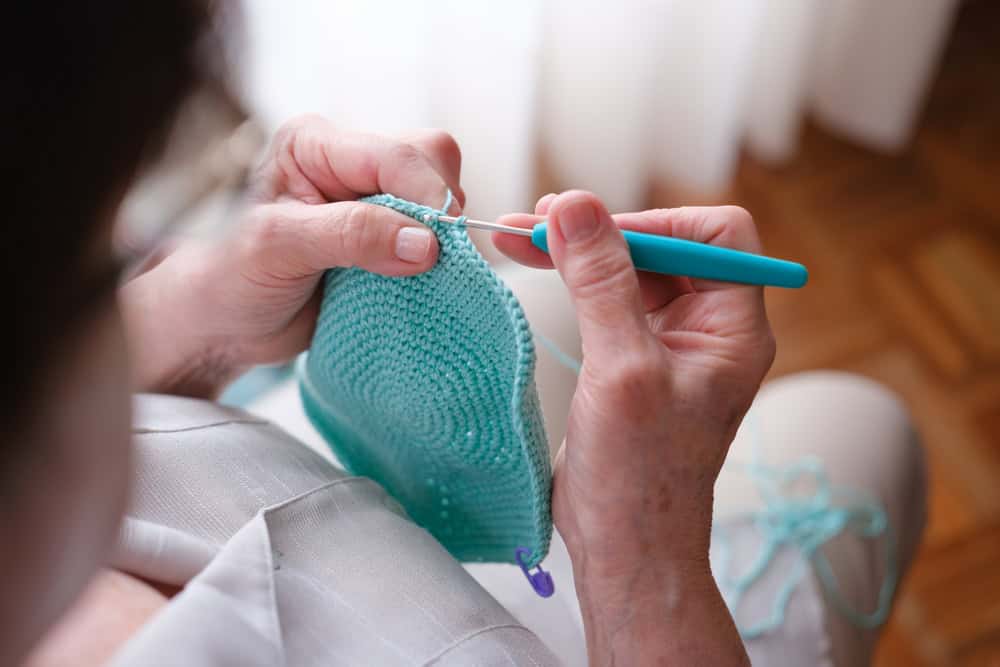 A woman shown crocheting